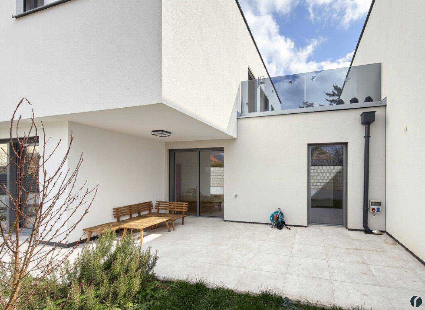 Außenbereich mit Terrasse, Grünfläche und direktem Zugang zum modernen Haus.