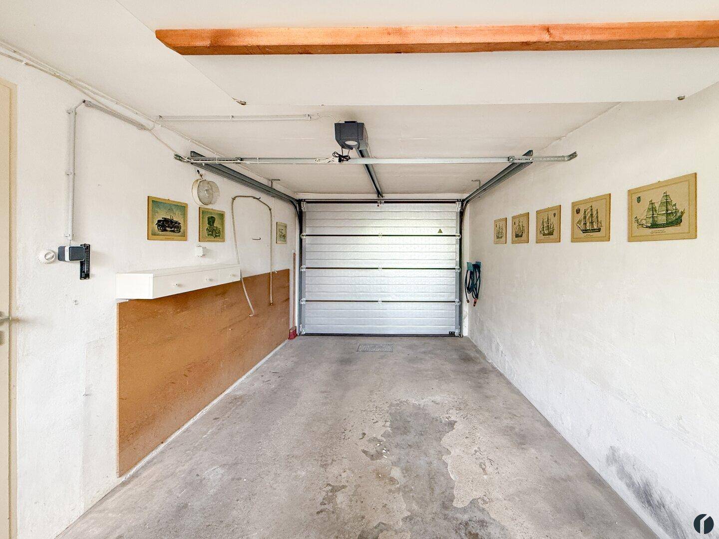 Geräumige Garage mit Betonboden und einem Rolltor.