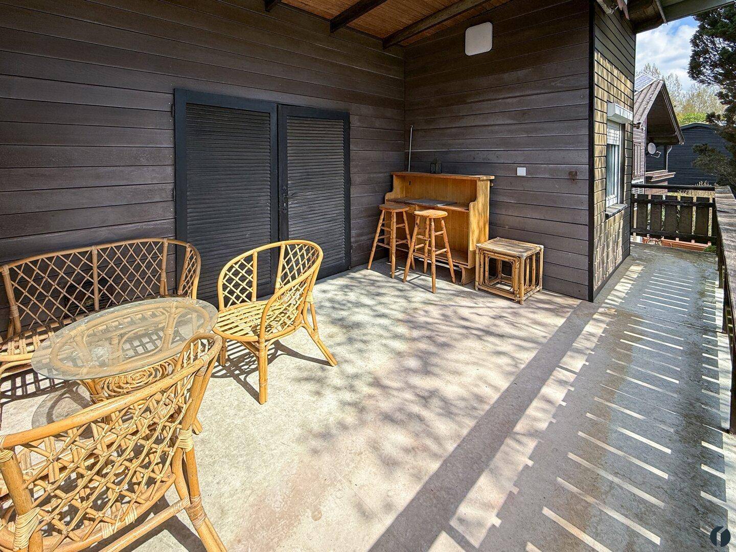 Geräumiger Balkon mit Rattanmöbeln und einer kleinen Bar, ideal für entspannte Stunden.