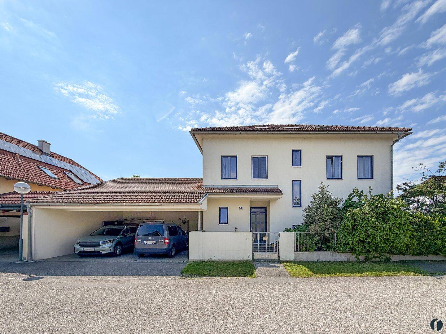 Vorderansicht des Hauses mit Carport für zwei Fahrzeuge und gepflegtem Eingangsbereich.