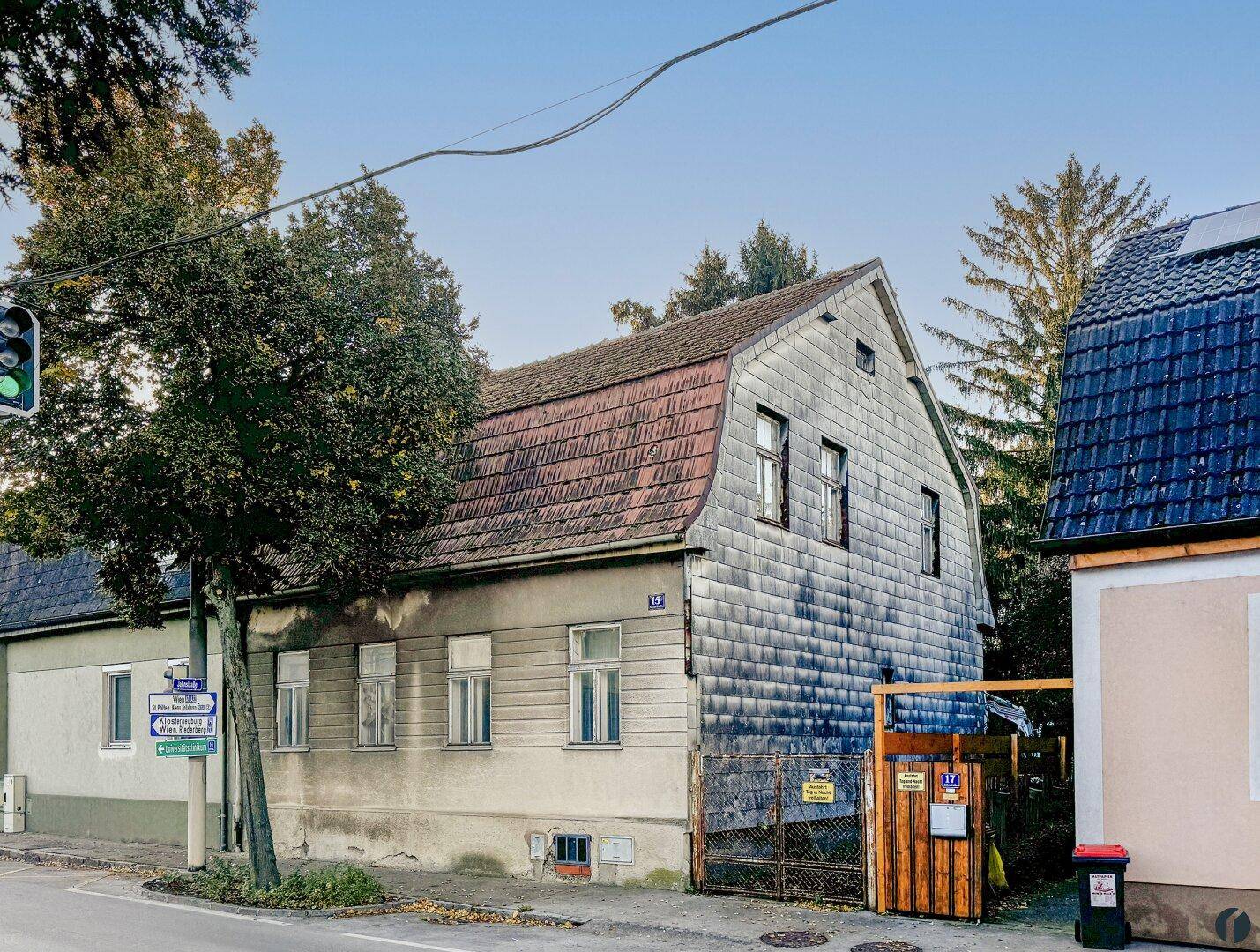 Altes Wohnhaus mit Schieferdach und Fassade, gelegen an einer ruhigen Straße mit Bäumen.