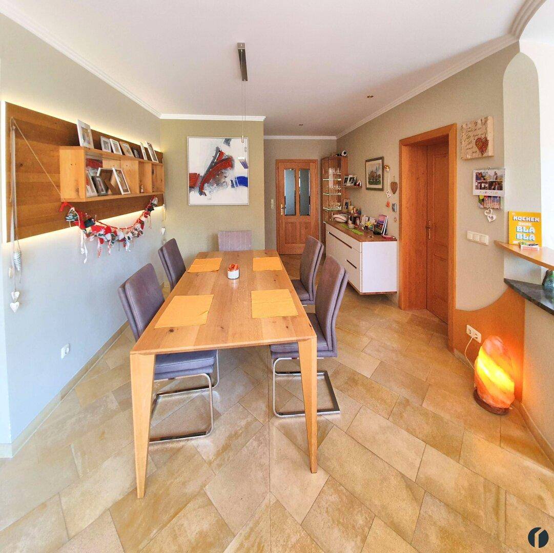Heller Essbereich mit Holztisch, modernen Stühlen und großformatigen Fliesenboden.