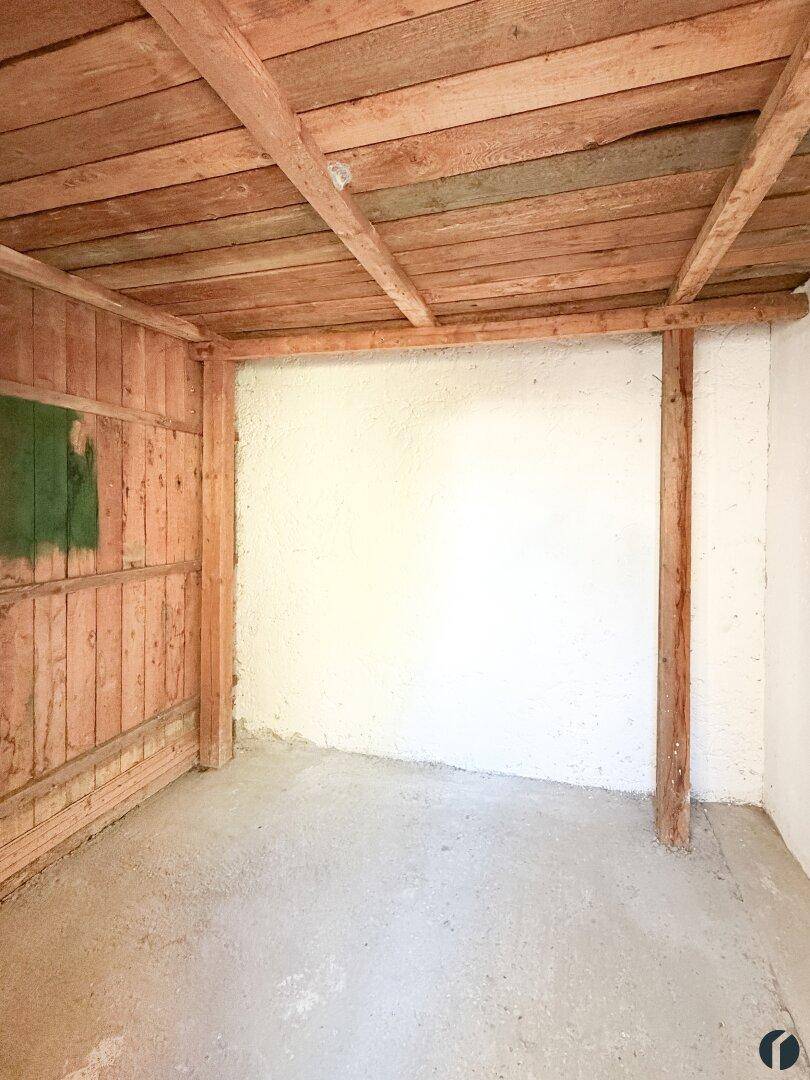 Rustikaler Abstellraum mit Holzbalkendecke und einfachen Wänden, ideal für Lagerung.