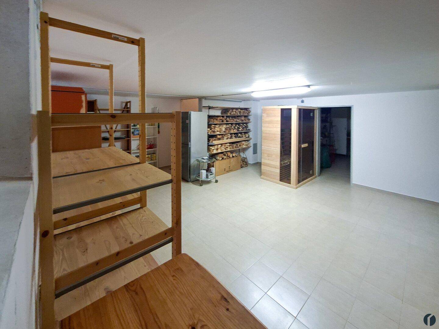 Geräumiger Kellerraum mit Regalen, Fliesenboden und einer integrierten Sauna für Wellness.
