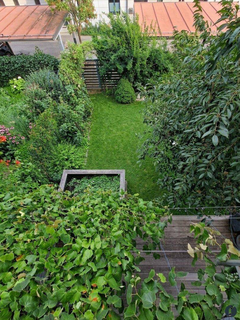 Vogelperspektive auf einen langen, schmalen Garten mit Rasenfläche und Bepflanzung.