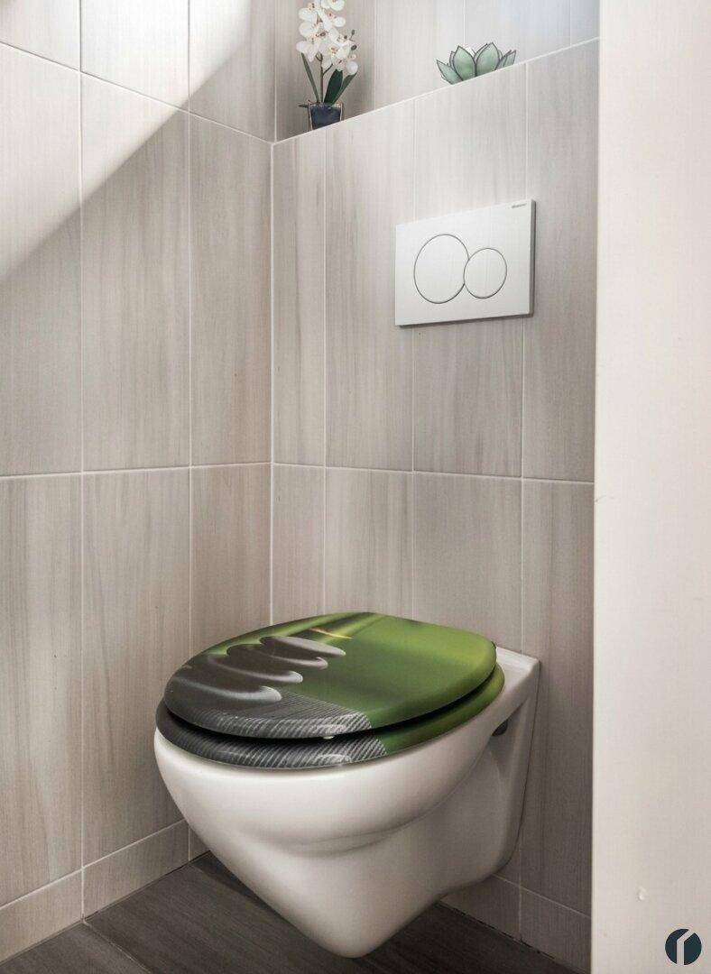 Modernes Gäste-WC mit wandhängender Toilette und grüner WC-Sitzabdeckung.
