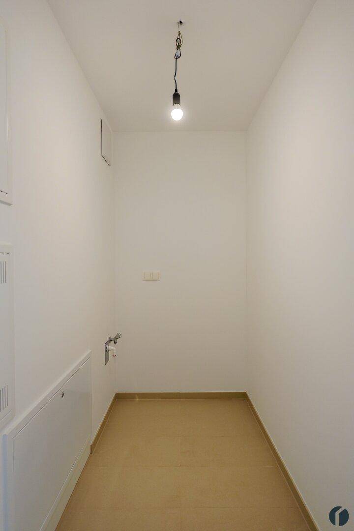 Kleiner Hauswirtschaftsraum mit Fliesenboden und Anschlüssen, ideal für Waschmaschine und Trockner.