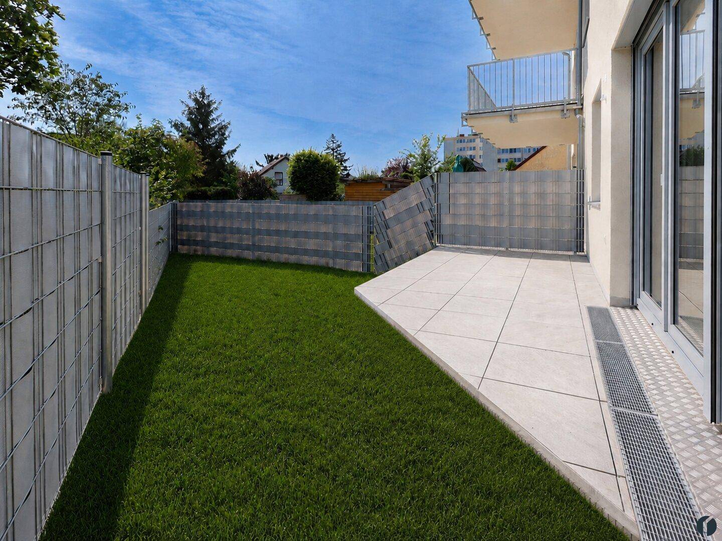 Terrasse mit direktem Zugang zum Garten und moderner Zaunanlage.