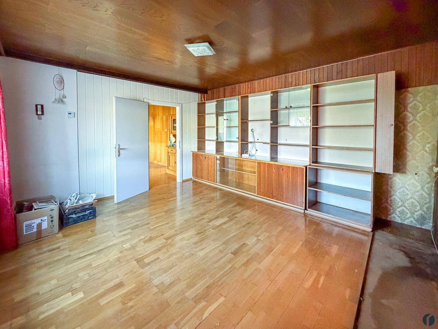 Wohnzimmer im traditionellen Stil mit Holzvertäfelung, Parkettboden und Einbauschränken.