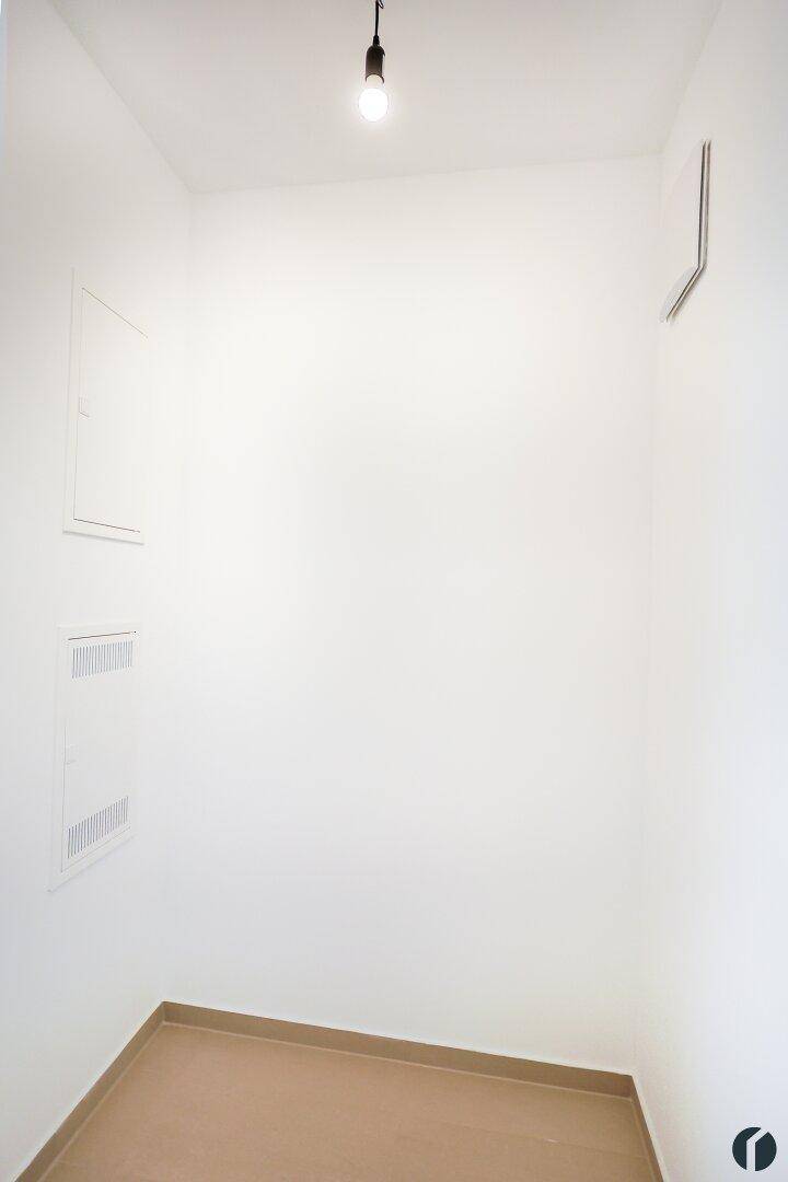 Kleiner Abstellraum mit Fliesenboden und weißen Wänden, ideal für Lagerzwecke.