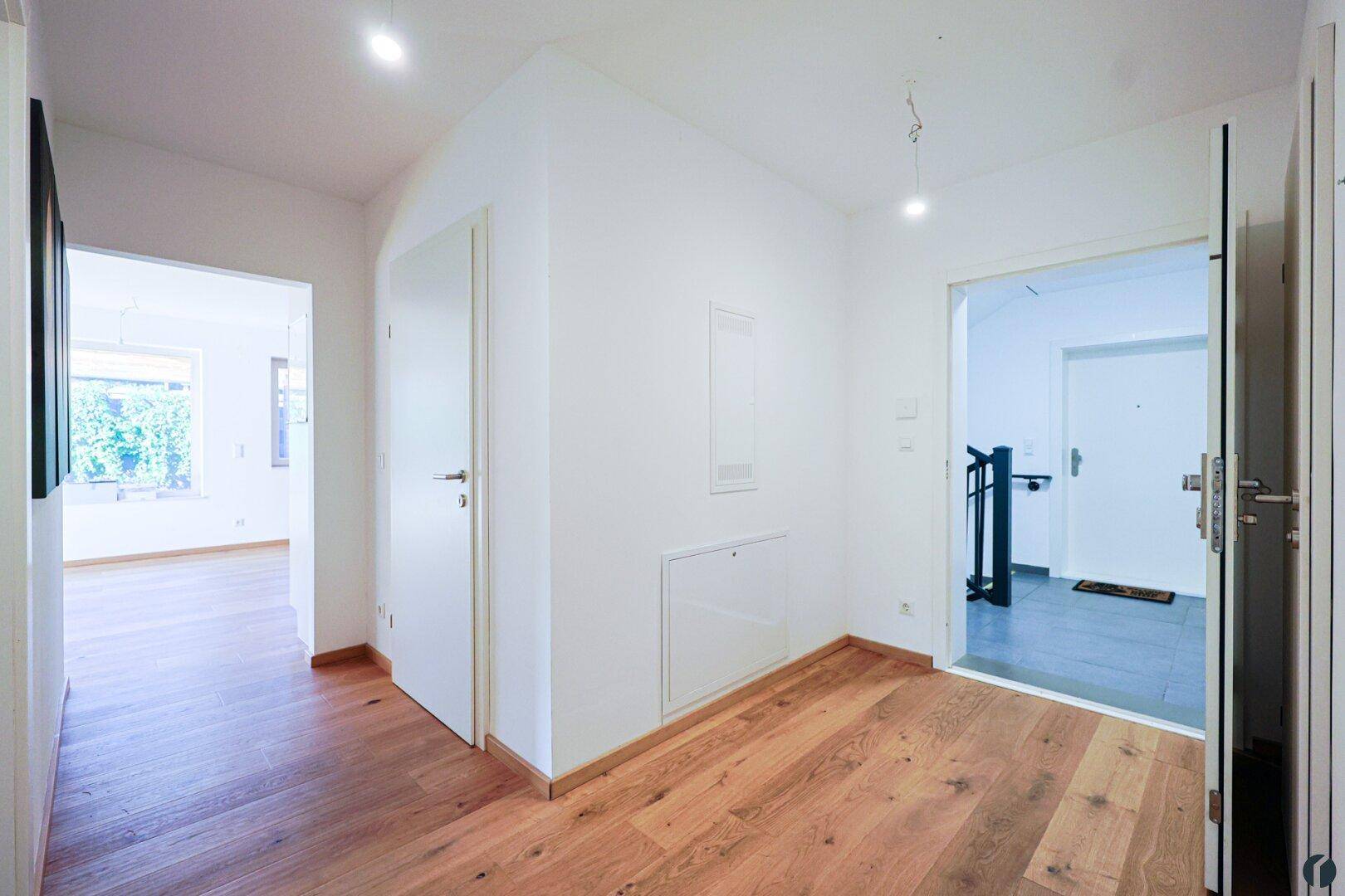 Heller Flur mit Eichenparkettboden und Zugang zu verschiedenen Räumen der Wohnung.