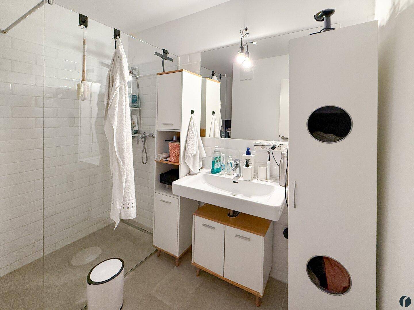 Modernes Badezimmer mit begehbarer Dusche, großem Waschbecken und weißen Fliesen.