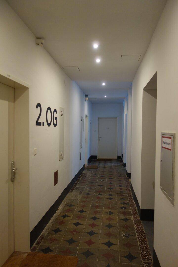Gemeinschaftsflur im zweiten Obergeschoss mit dekorativen Bodenfliesen und moderner Deckenbeleuchtung.