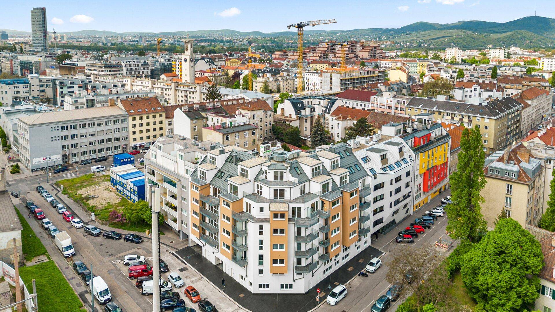 Weitläufige Luftaufnahme eines modernen Wohngebäudes in der Stadt mit umliegender Bebauung.