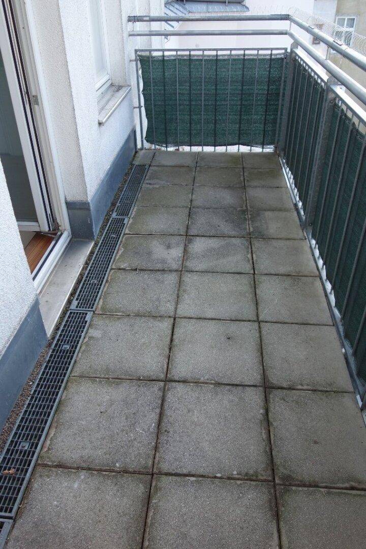 Geräumiger Balkon mit Fliesenboden und Metallgeländer, ideal für entspannte Stunden im Freien.