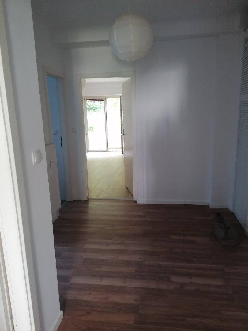 Heller Flurbereich mit Laminatboden und Zugang zu angrenzenden Räumen, gut beleuchtet.