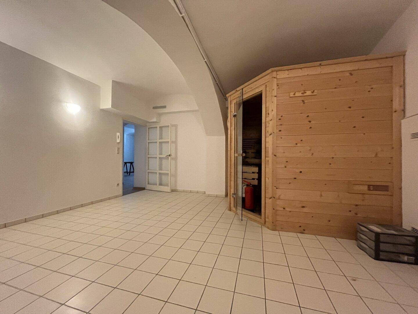 Wellnessbereich mit Sauna und Fliesenboden, ideal zur Entspannung.