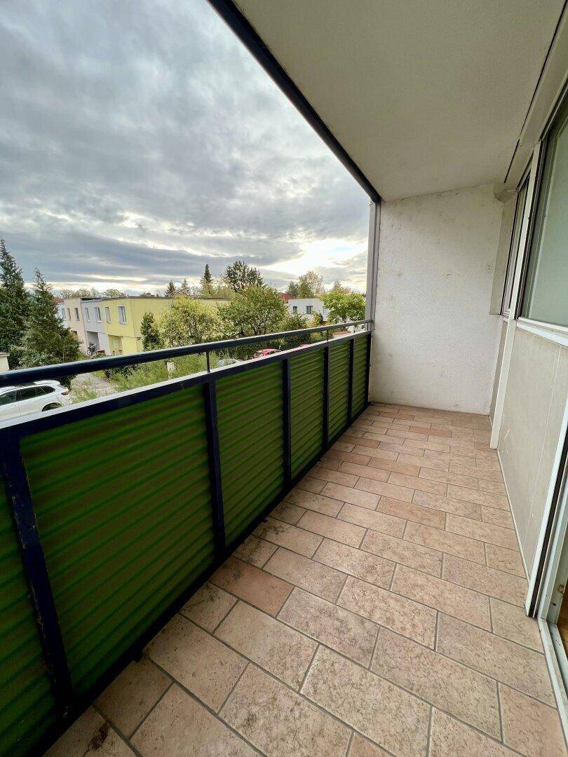 Balkon mit Fliesenboden und grüner Brüstung, bietet einen weiten Blick auf die Umgebung.