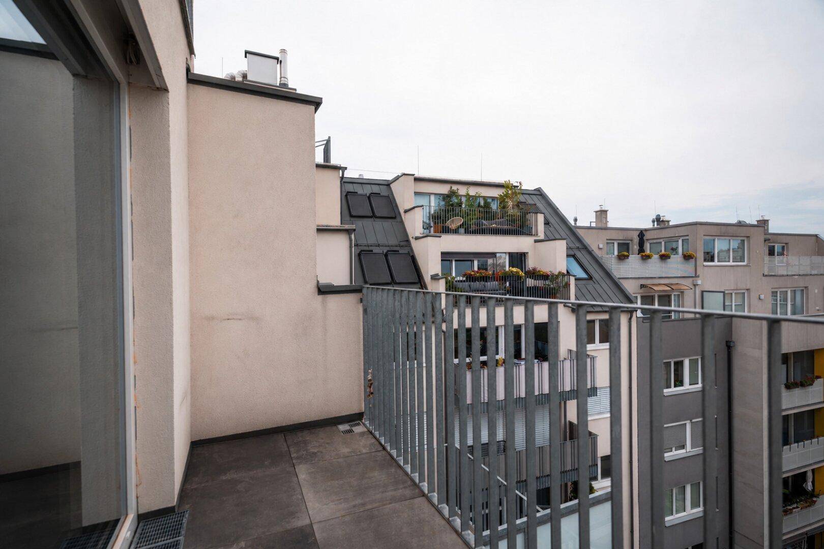 Balkon mit Blick auf die umliegenden Gebäude und weitere Balkone der modernen Wohnanlage.