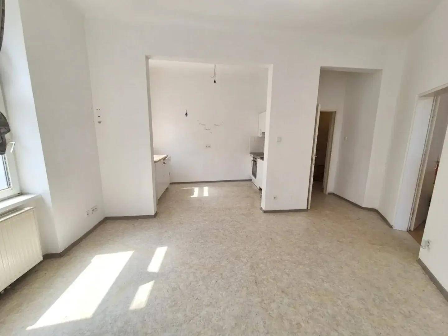 Offener Wohnbereich mit angrenzender Küchenzeile und viel Gestaltungspotenzial für moderne Wohnkonzepte.