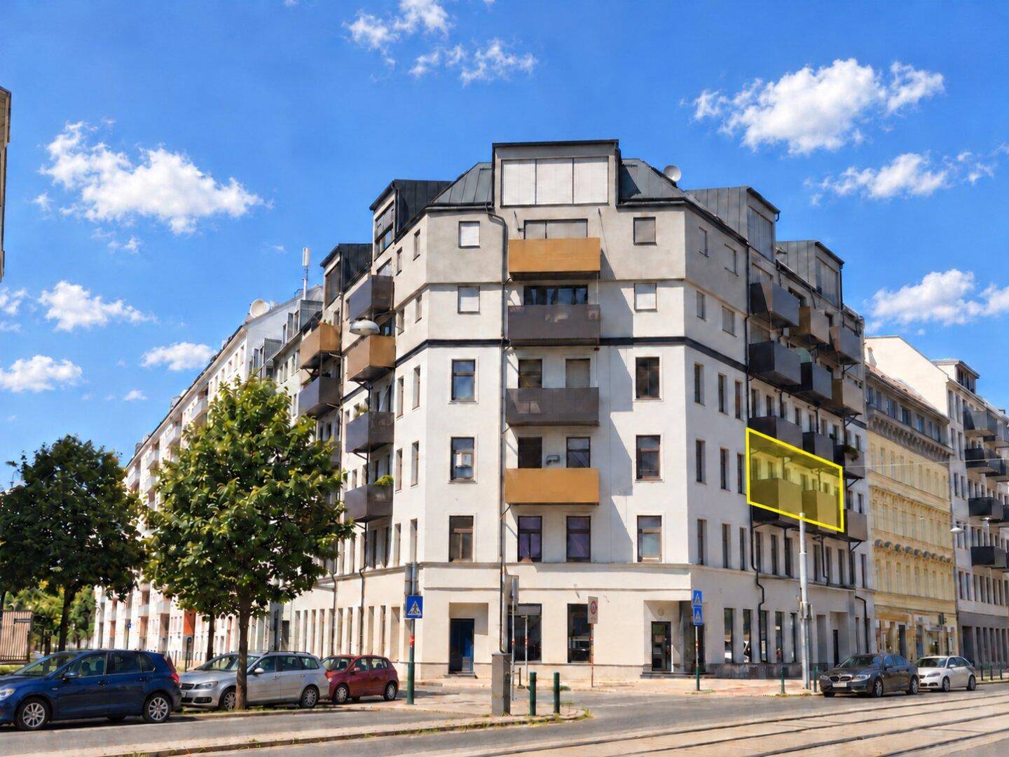 Wohngebäude mit Balkonen und moderner Fassade unter blauem Himmel in der Stadt.