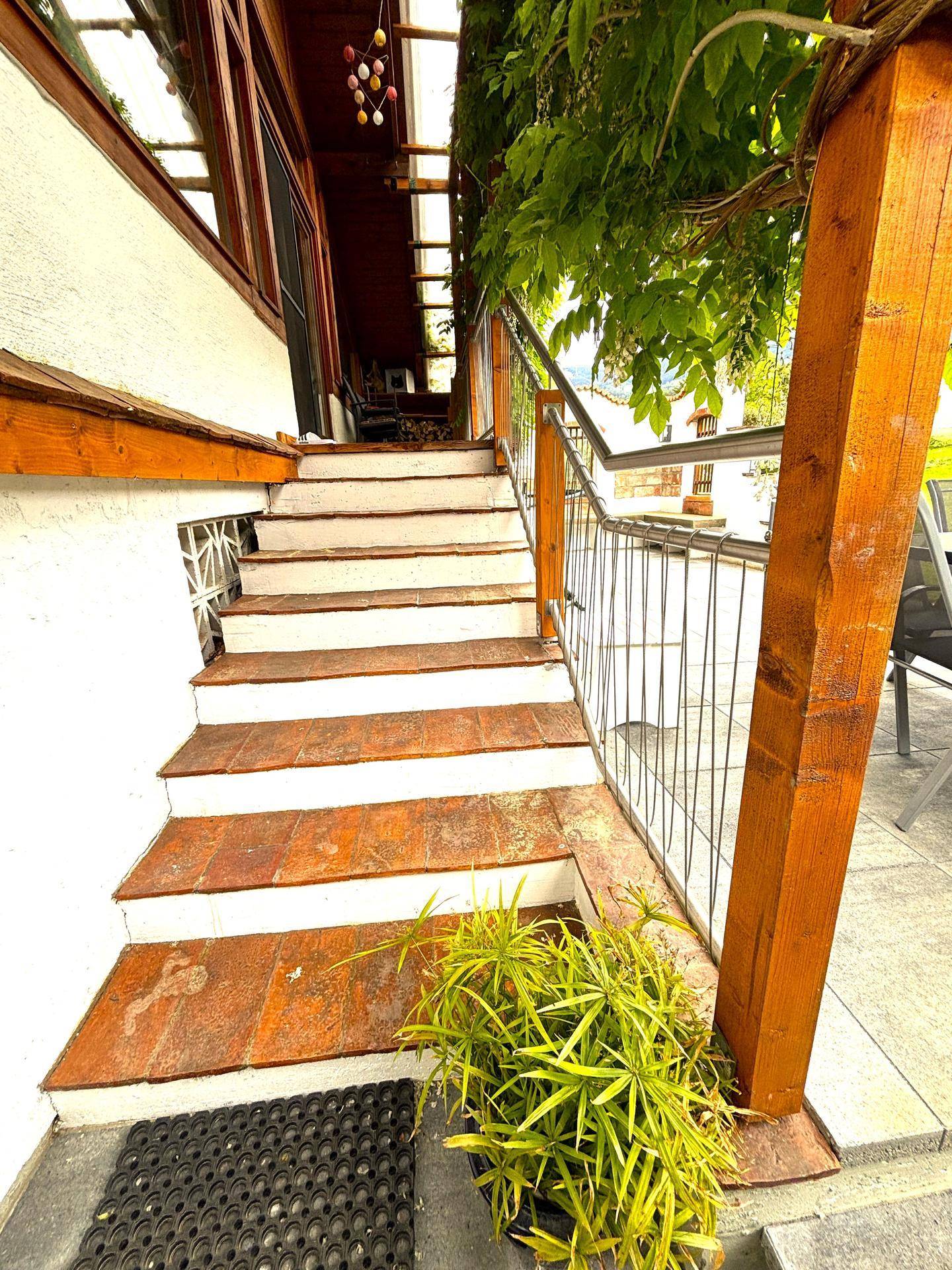 Außentreppe mit Terrakotta-Stufen führt von der Terrasse zum oberen Bereich des Hauses.