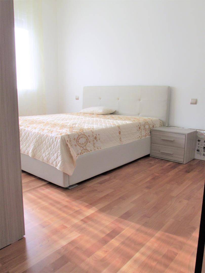 Schlafzimmer mit Doppelbett, Nachttischen und hellem Holzboden.