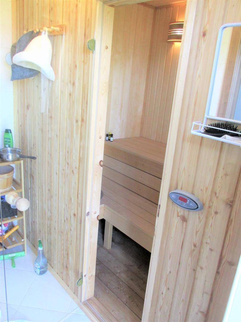 Innenansicht der Holzsauna mit Sitzbänken und Steuerungselementen für Entspannung.