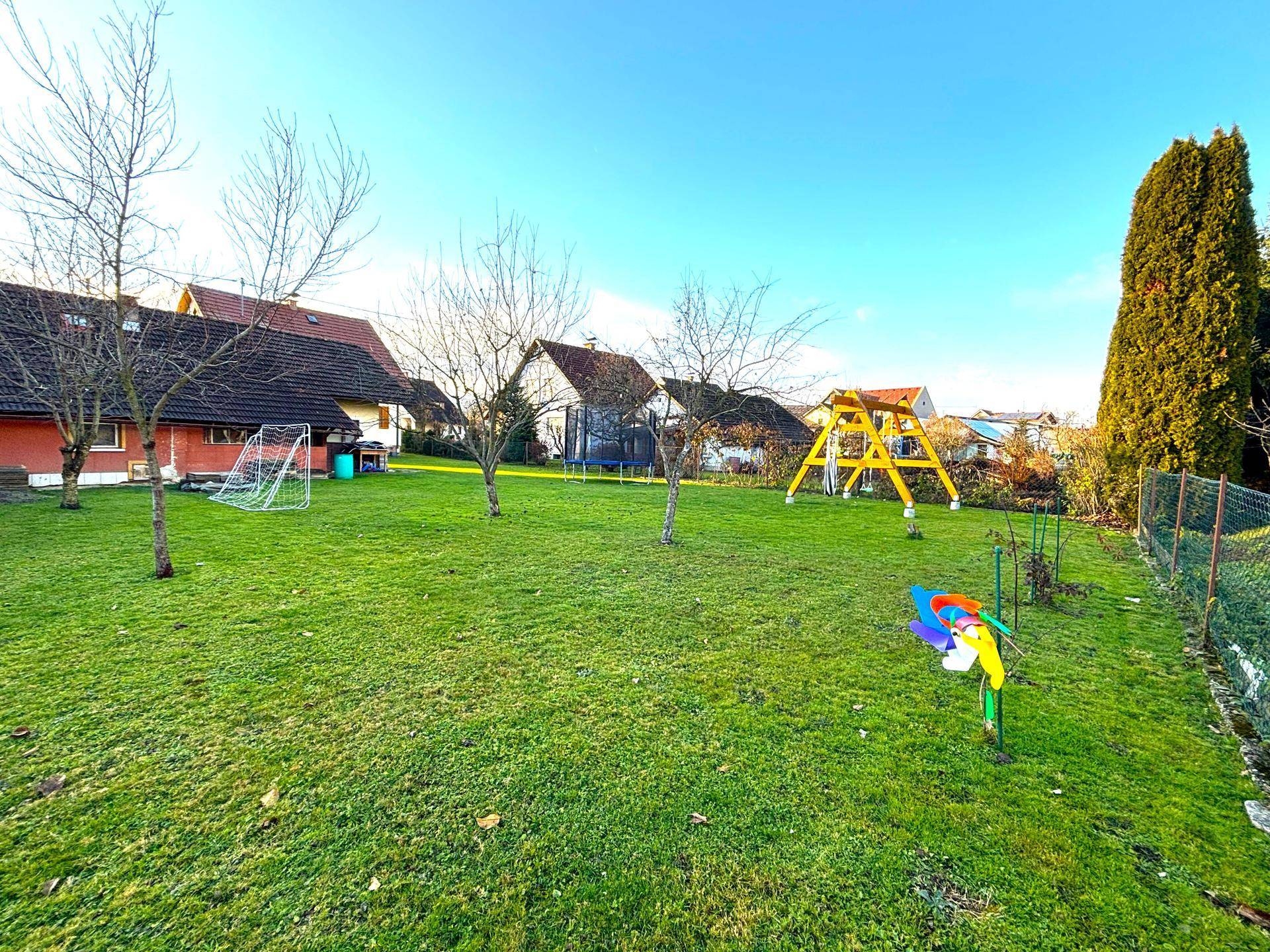 Weitläufiger Garten mit Rasenfläche, Schaukel und Fußballtor, ideal für Kinder und Freizeitaktivitäten.