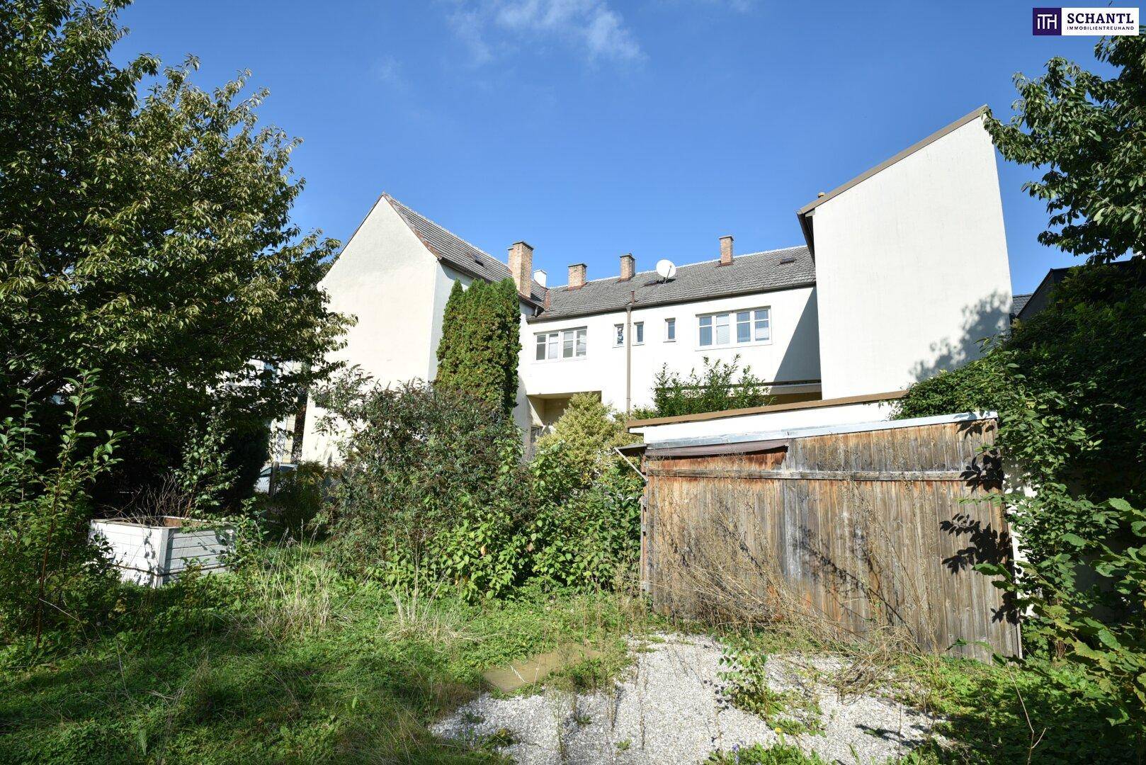 Rückansicht eines Mehrfamilienhauses mit grüner Umgebung und altem Holzschuppen.