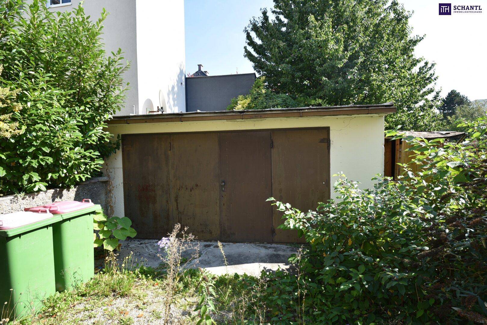 Einzelgarage mit braunen Toren und umgebendem Grünbereich, neben Mülltonnen.
