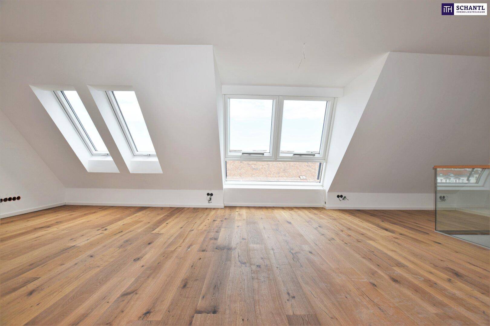 Heller Dachgeschossraum mit Holzboden, Dachschrägen und großen Fenstern für viel Tageslicht.
