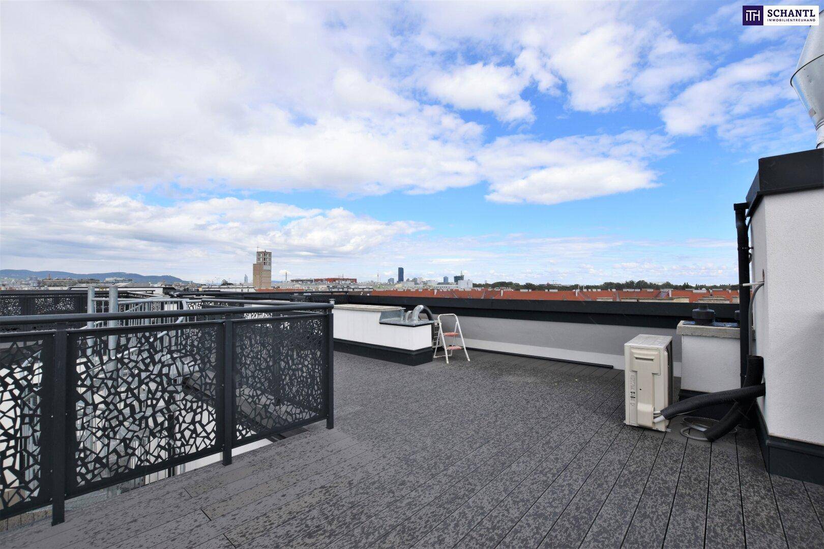 Große Dachterrasse mit dunklem Bodenbelag, Metallgeländer und weitem Stadtblick.