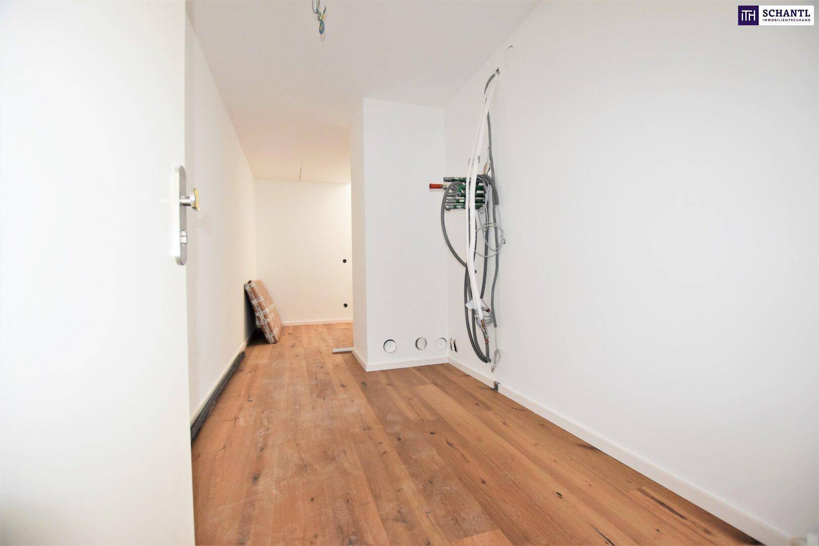 Unfertiger Flur mit Holzboden und sichtbaren Elektroinstallationen, bereit für den Ausbau.