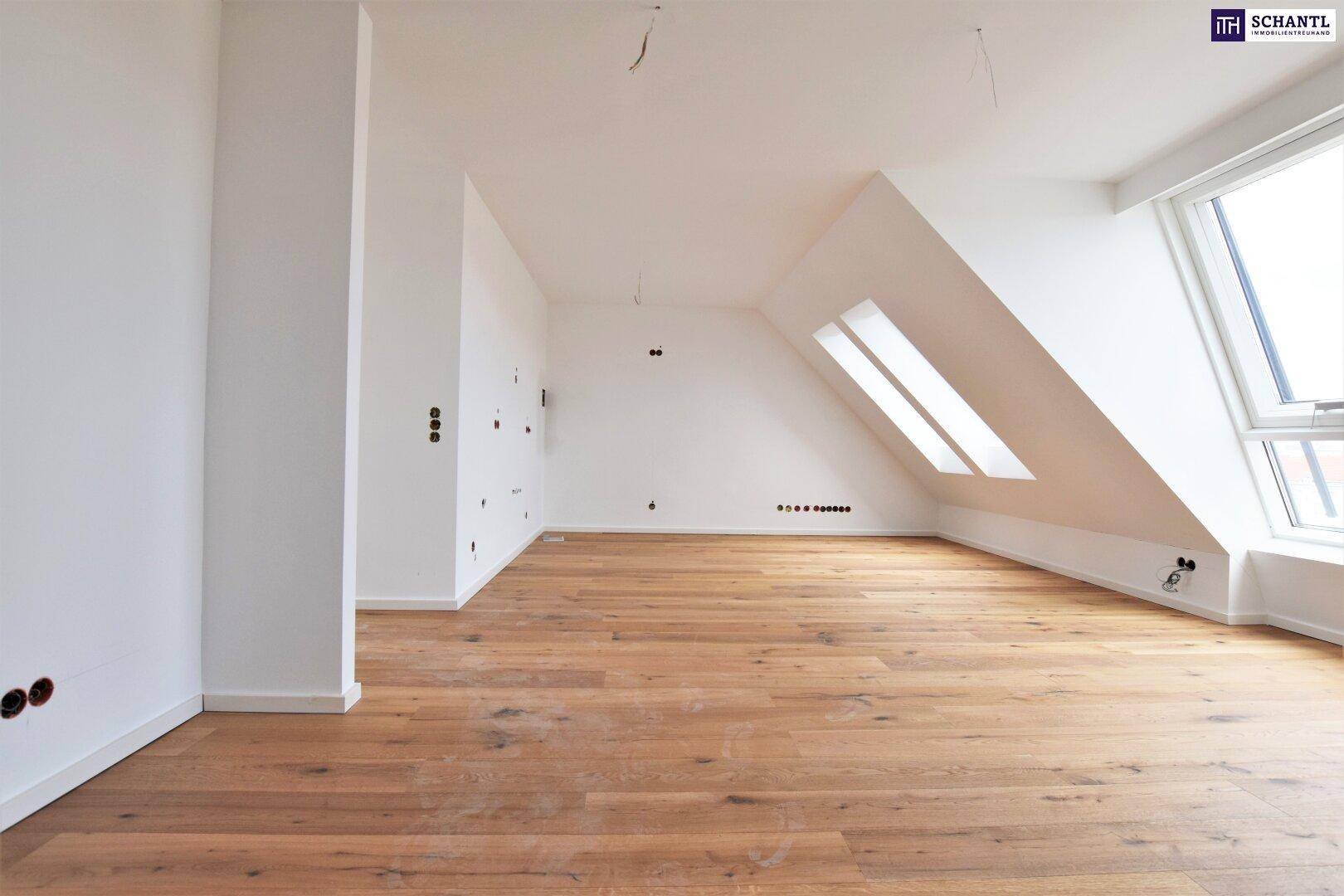 Heller Dachgeschossraum mit Holzboden, Dachschrägen und großen Fenstern, bereit für die Einrichtung.