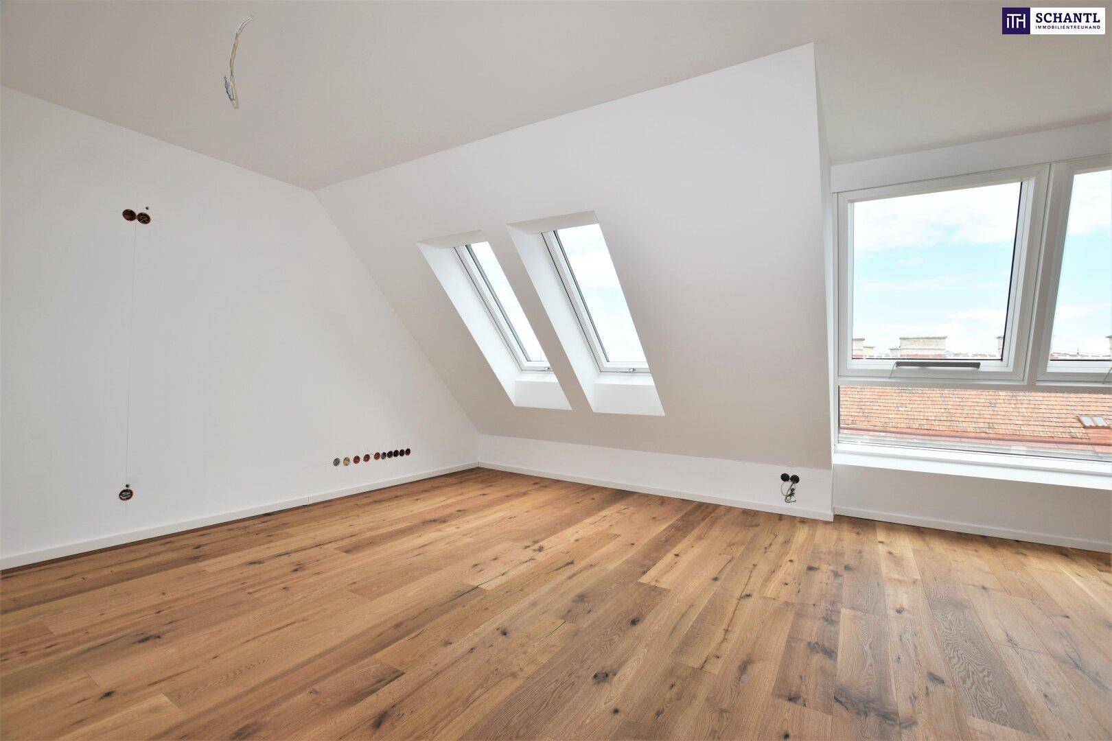 Lichtdurchfluteter Dachgeschossraum mit Holzboden, Dachschrägen und mehreren Fenstern.