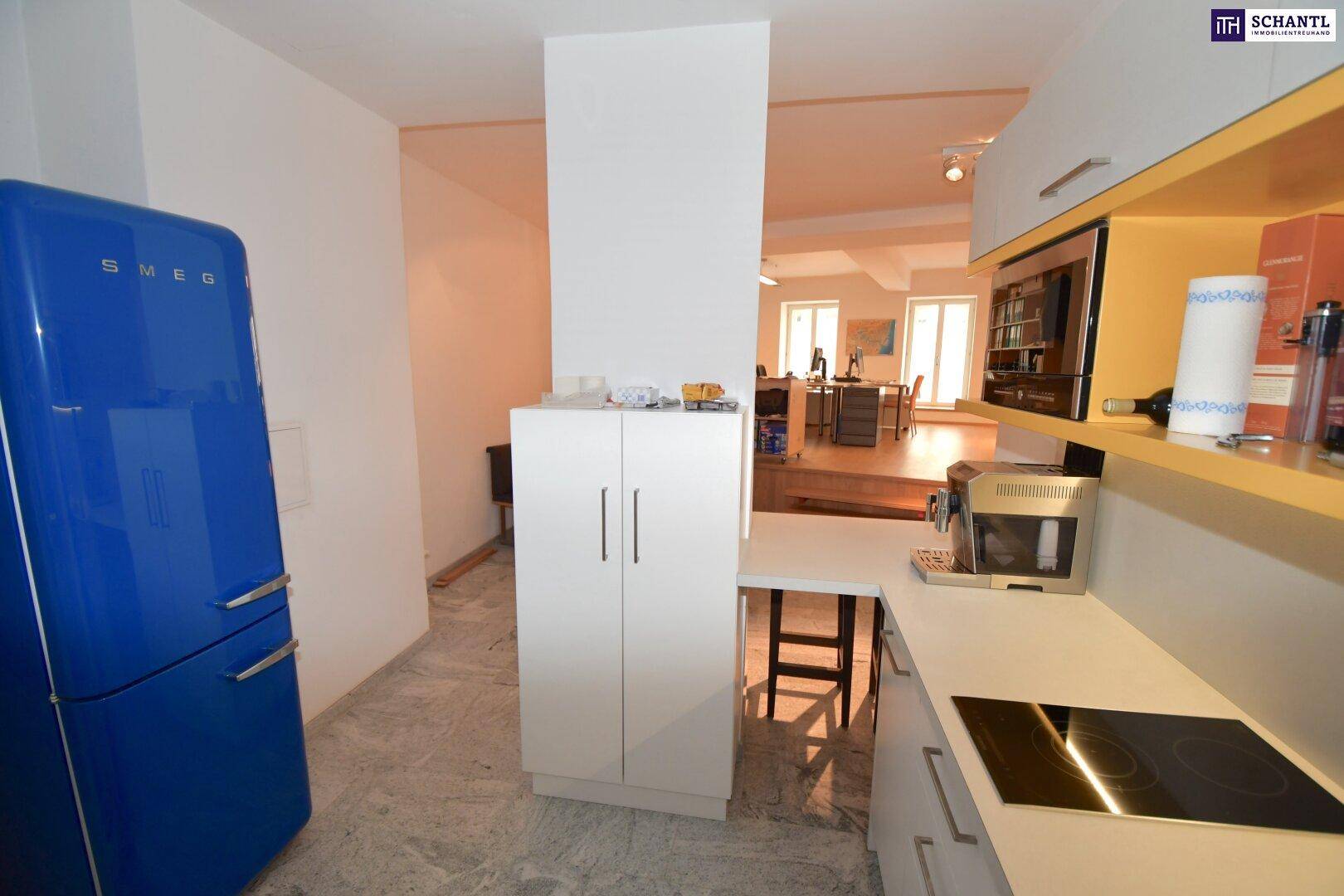 Kompakte Küche mit modernem Design und einem auffälligen blauen Retro-Kühlschrank.