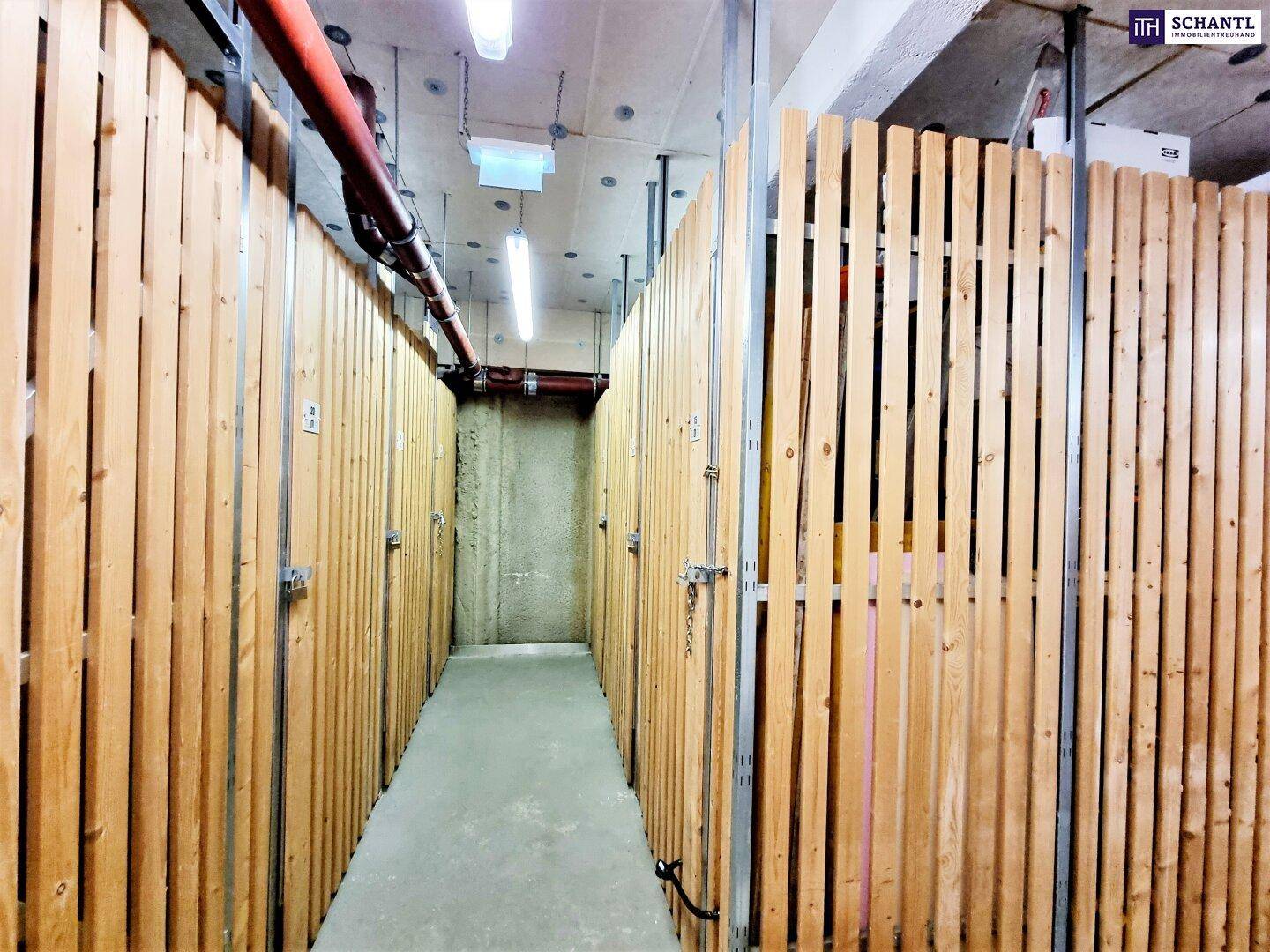 Reihe von Kellerabteilen mit Holzlattenwänden im Untergeschoss, gut organisiert und sicher.