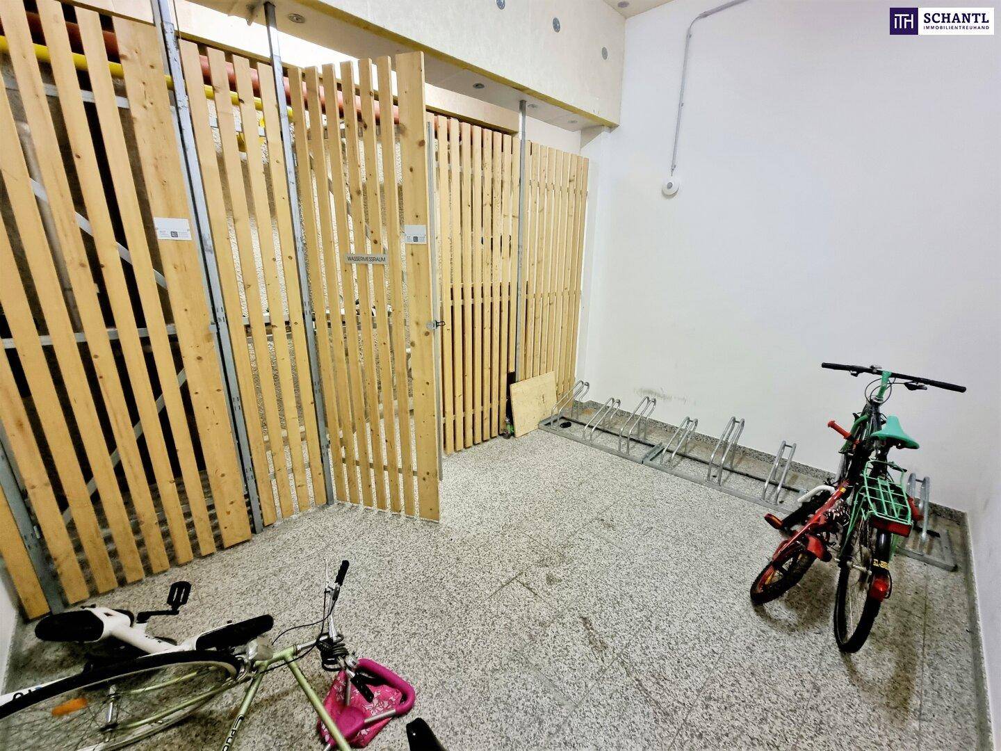 Fahrradraum mit Abstellmöglichkeiten und Holzabtrennungen für zusätzlichen Stauraum.
