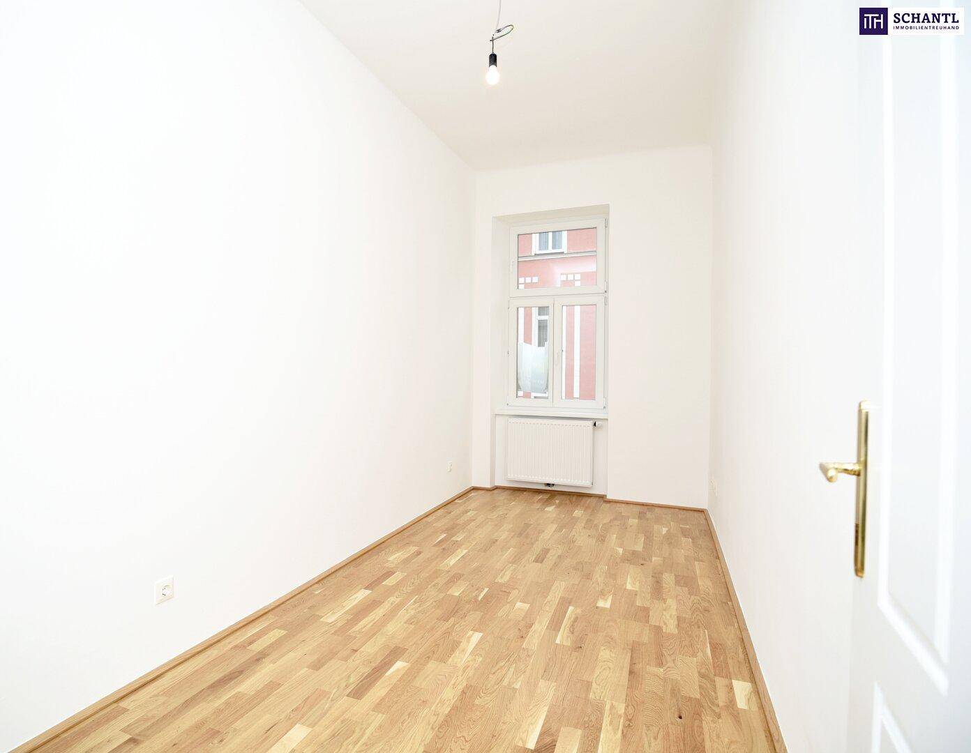 Leeres Zimmer mit Holzboden und einem Fenster, bereit zur individuellen Gestaltung.