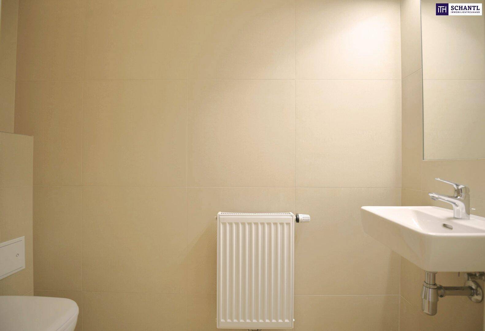 Modernes WC mit Wand-WC, Waschbecken und Heizkörper an der gefliesten Wand.