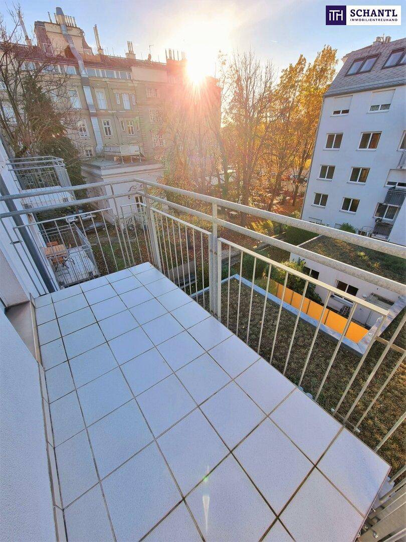 Sonniger Balkon mit Fliesenboden und Blick auf die umliegenden Gebäude und Grünflächen.