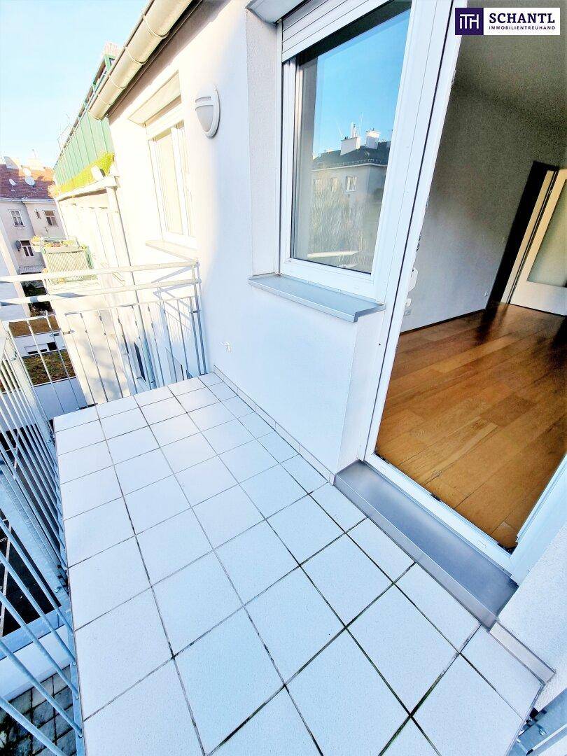 Heller Balkon mit Fliesenboden und Zugangstür, bietet einen Blick auf die Nachbarschaft.