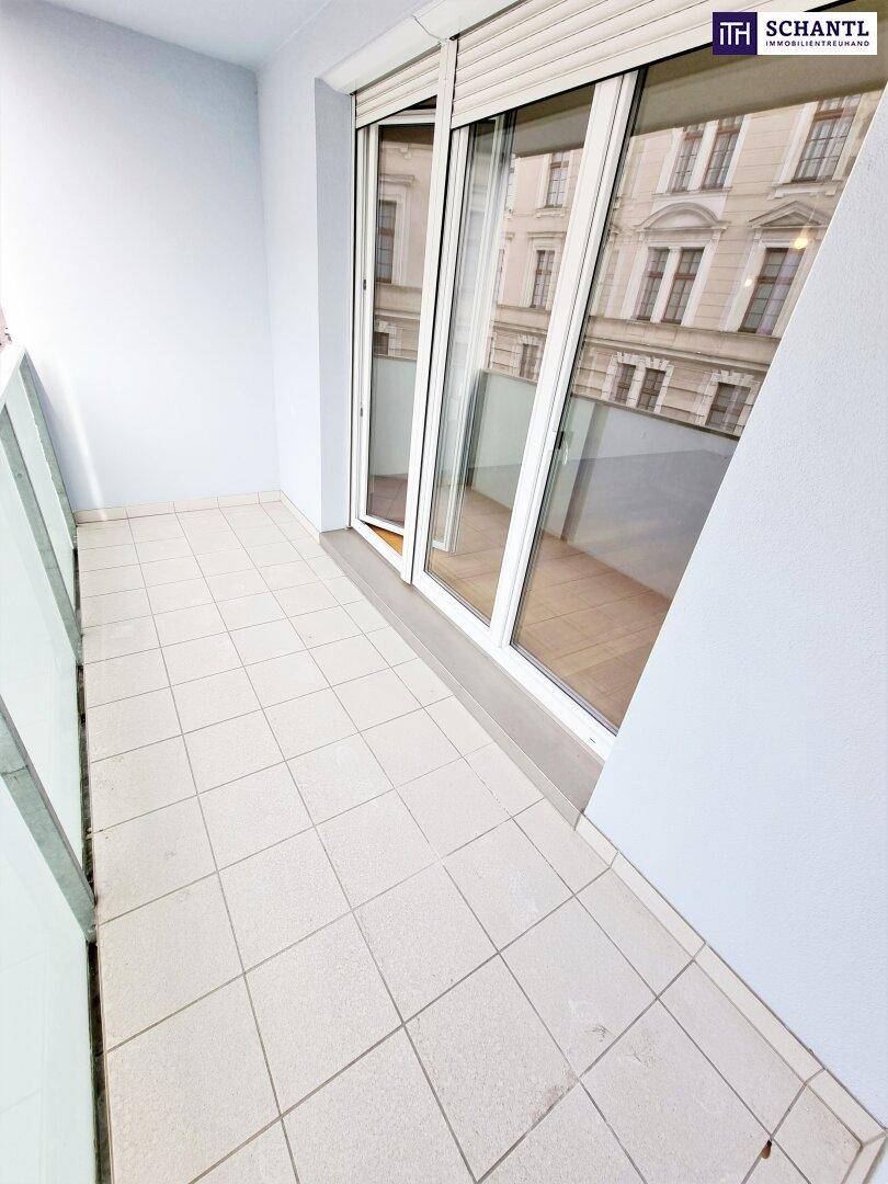 Kleiner Balkon mit Fliesenboden und Glasbrüstung, ideal für einen ruhigen Moment.