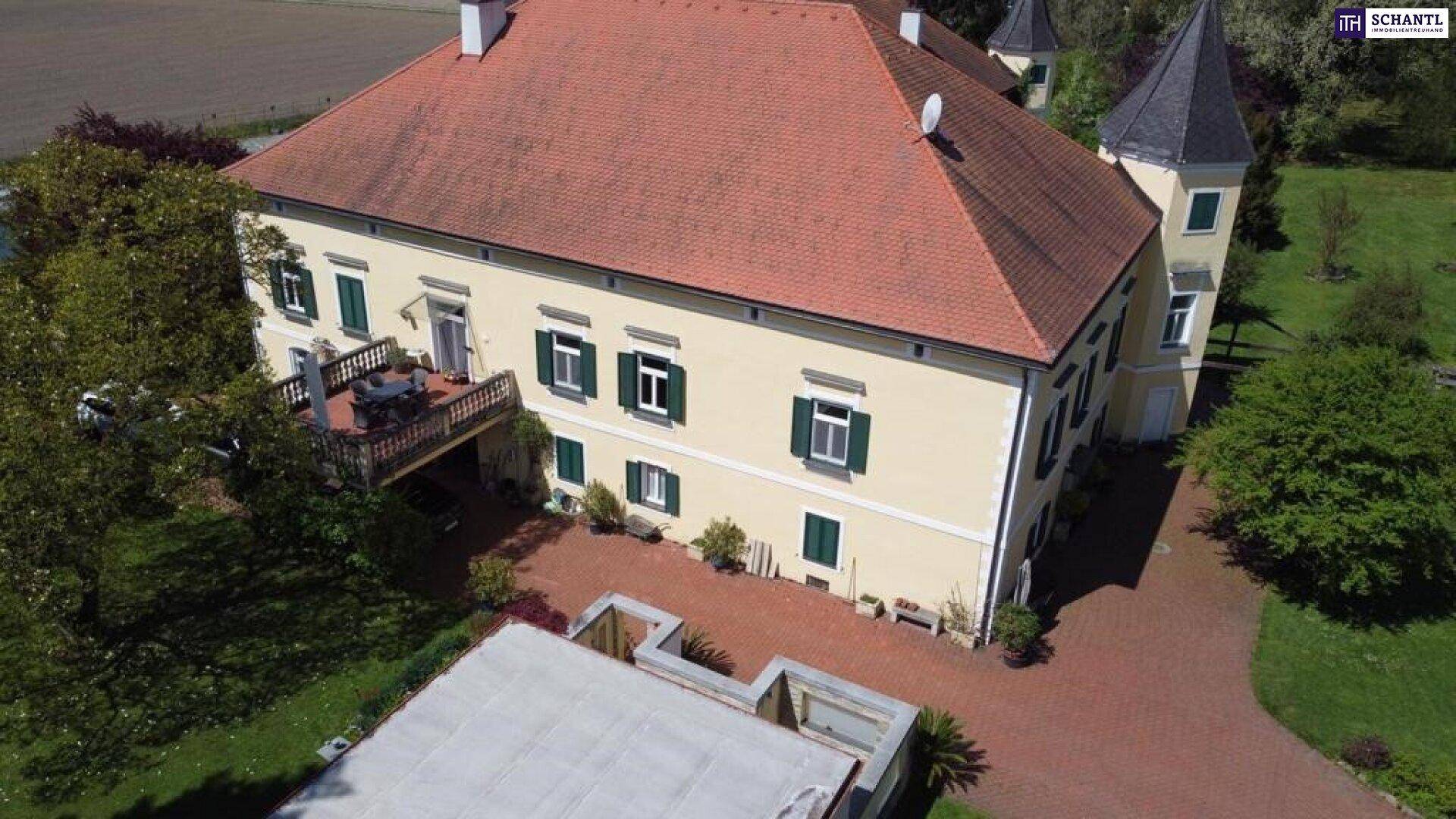 Luftaufnahme der Rückseite des Gebäudes mit einer möblierten Terrasse und gepflastertem Bereich.