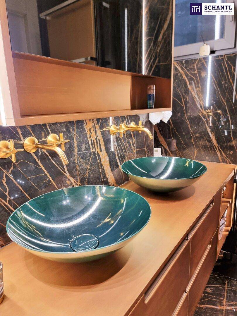Detailansicht des Holzwaschtischs mit zwei grünen Aufsatzwaschbecken und goldenen Wandarmaturen.