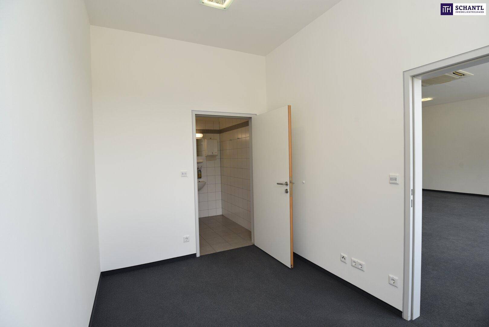 Eingang zu einem Badezimmer mit Fliesenboden und weißen Wänden, das eine Dusche und Toilette enthält.