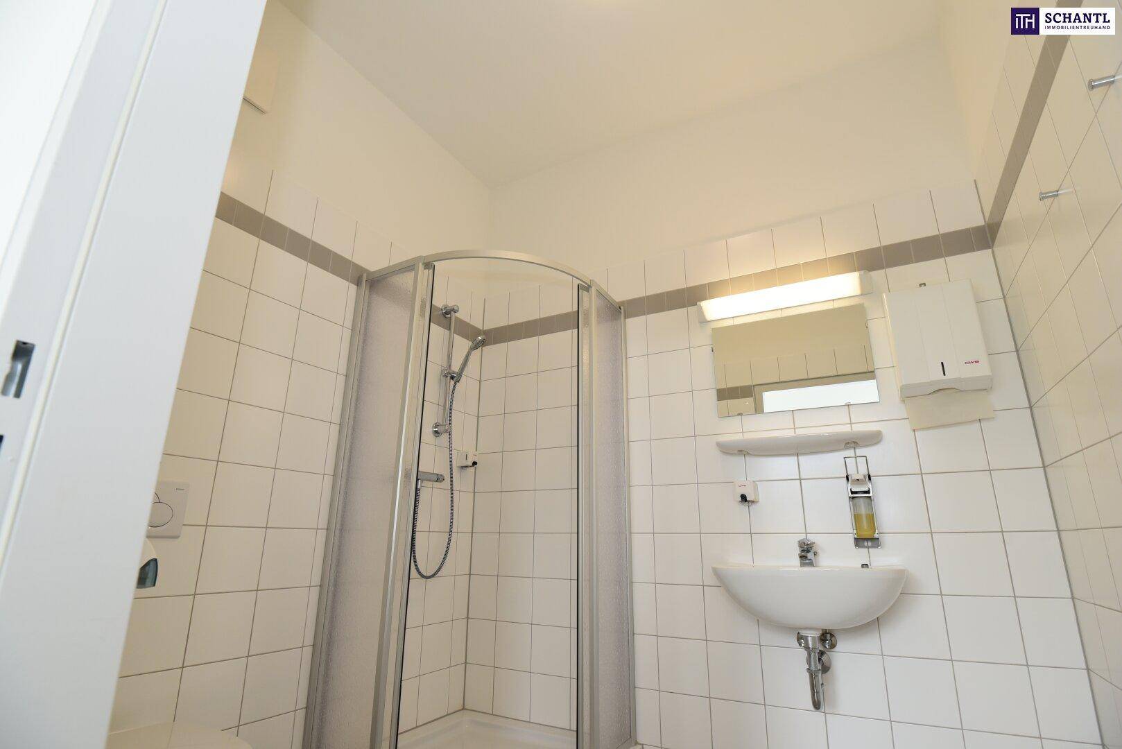 Modernes Badezimmer mit weißen Fliesen, Duschkabine und Waschbecken, ideal für den täglichen Gebrauch.
