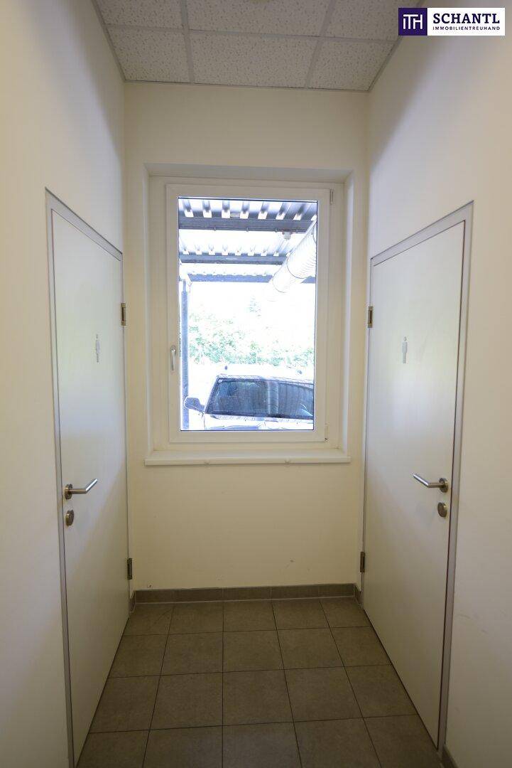 Kleiner Flur mit Fenster und zwei Türen, der zu den Toiletten führt.