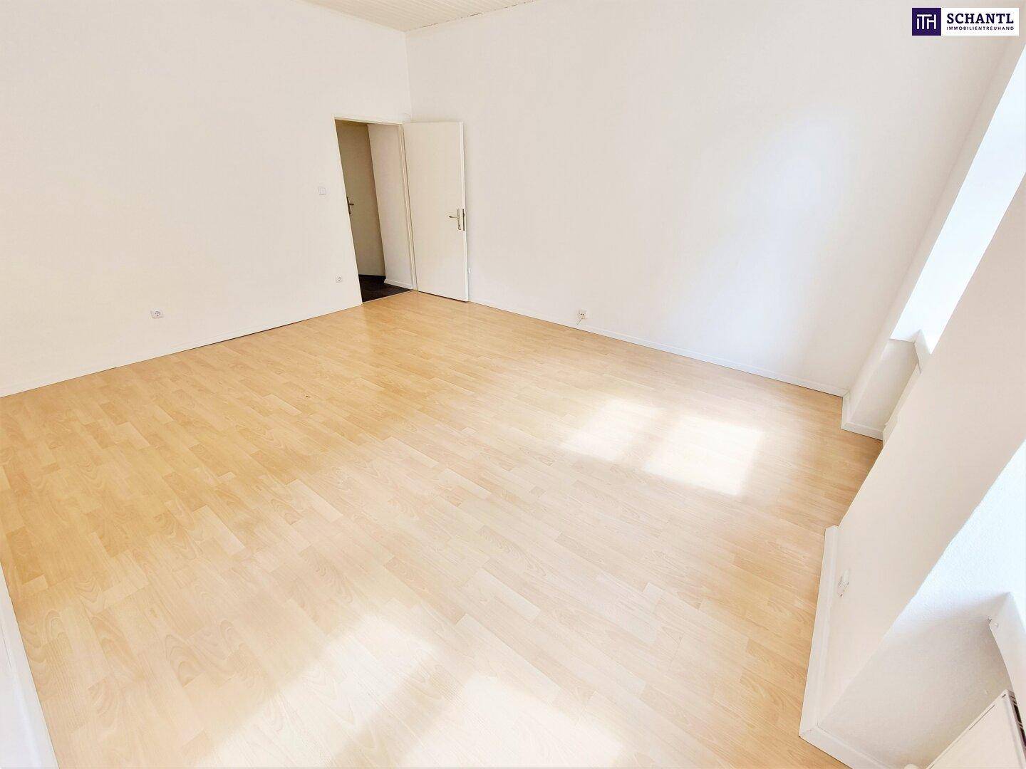 Geräumiges Zimmer mit hellem Holzfußboden und weiß gestrichenen Wänden, bereit zur Einrichtung.